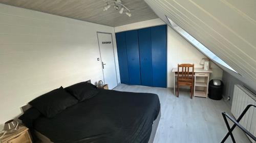 a bedroom with a black bed and a blue door at Entre terre et mer in Combrit