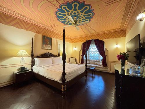 a bedroom with a large bed with a coffered ceiling at Fort Rajwada,Jaisalmer in Jaisalmer