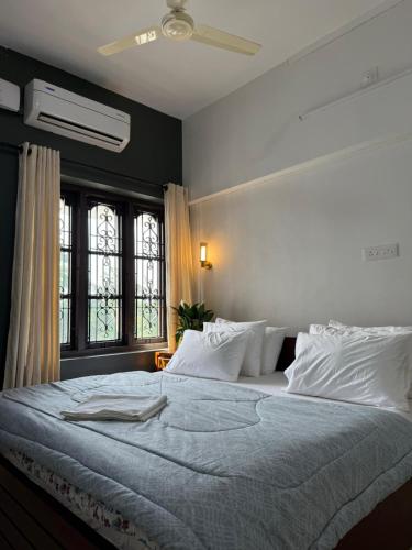 a bedroom with a large bed with white pillows at DOWN TOWN HOLIDAYS Kovalam in Kovalam