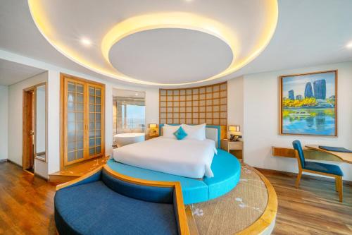 a bedroom with a large bed and a table at Sala Danang Beach Hotel in Danang