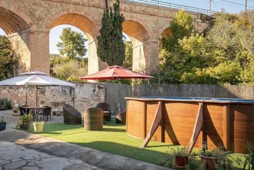 an outdoor patio with a table and an umbrella at AT504 Rustic house with private pool in Roda de Bará