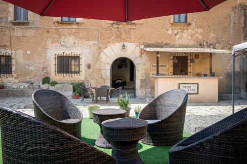 a group of chairs and tables with an umbrella at AT504 Rustic house with private pool in Roda de Bará