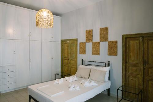 a bedroom with a white bed and a chandelier at Anna's House in Koufonisia