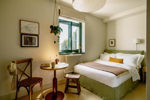 a bedroom with a bed and a table and a window at Mason & Fifth, Bermondsey in London