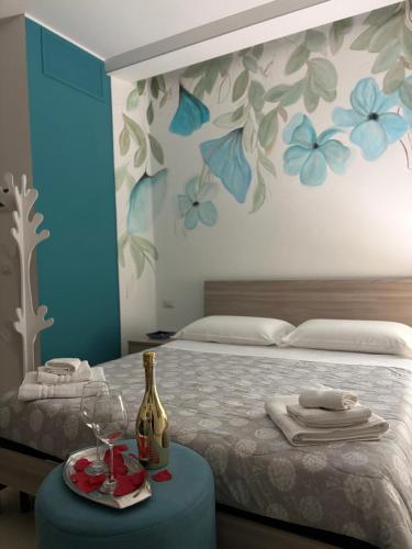 a bedroom with a bed and a table with a bottle of wine at Massanè Casa Vacanza in Ginosa