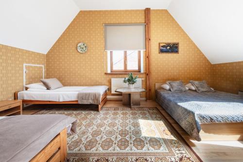 a bedroom with two beds and a rug at Aismares in Klaipėda
