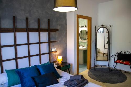 a bedroom with a bed with blue pillows and a mirror at Apartamento amplio con gran terraza y vistas in Monachil