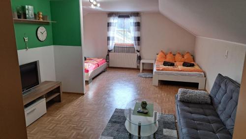 a living room with a couch and a tv at Ferienwohnung Pölzlbauer in Neuwald