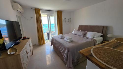 a hotel room with a bed and a television at Apartmani Luan in Vis