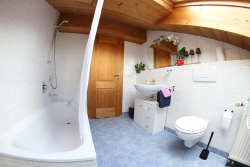 a bathroom with a tub and a toilet and a sink at Christina's Bergblick in Oberammergau