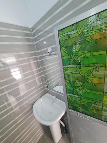 a bathroom with a white toilet and a painting on the wall at A & S residences in Pannipitiya