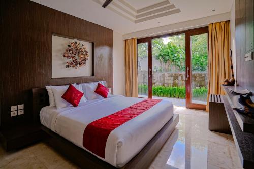 a bedroom with a large bed with red pillows at Villa Campania in Blahbatu