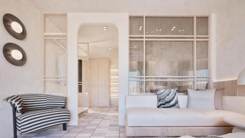 a living room with a white couch and a chair at Pefkos Blue in Pefki