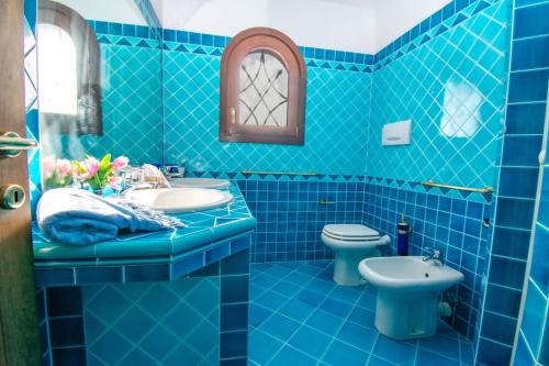 a blue bathroom with a sink and a toilet at Villa Azzurra in Cannigione
