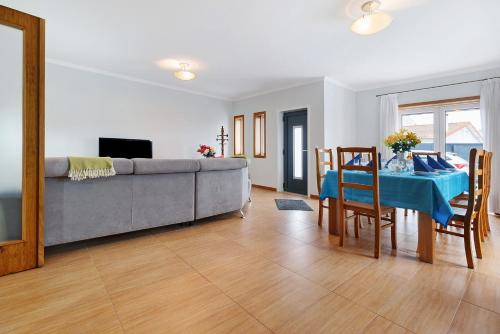 a living room with a couch and a dining room table at Vivenda Sol e Mar in Gafanha da Nazaré