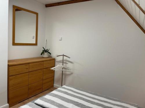 a bedroom with a wooden dresser and a mirror at Ferienhaus Alex - Wohnung im DG in Malliß