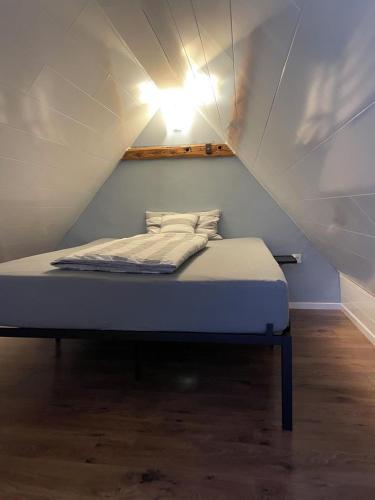 a bed in a attic with a light on it at Ferienhaus Alex - Wohnung im DG in Malliß