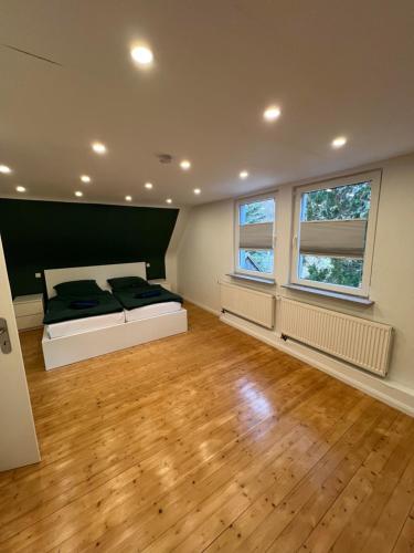 a bedroom with a bed and two windows at Ferienhaus mit Trifelsblick in Annweiler am Trifels