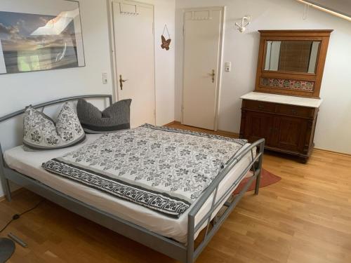 a bedroom with a bed and a dresser at Seelenbaumlerin in Schliersee