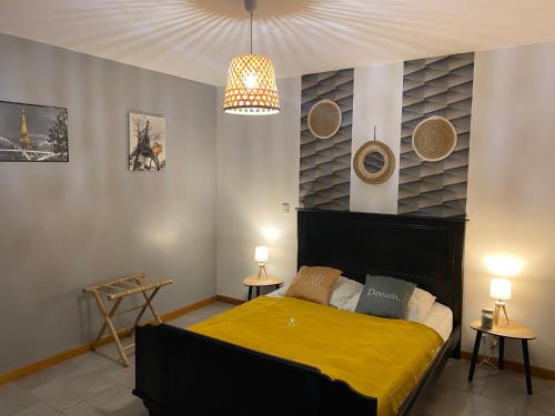 a bedroom with a bed with a yellow blanket at Gîte cosy 6 personnes, avec jardin en Normandie, proche des plages du débarquement et du Mont Saint-Michel in La Luzerne