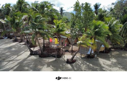a group of palm trees in front of a building at Island Crib in El Nido