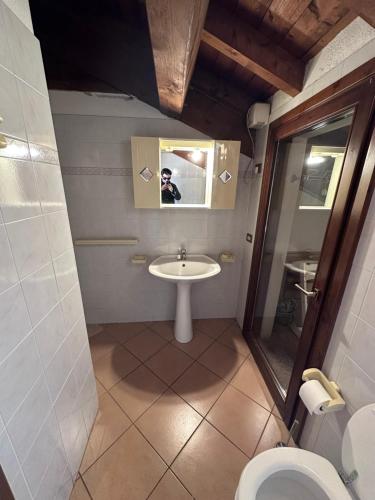 a bathroom with a sink and a toilet and a mirror at Dante 12 Flat in Cremona
