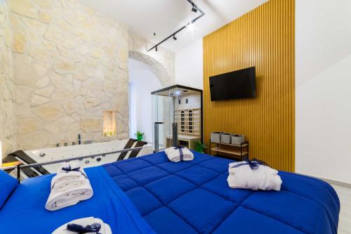 a bathroom with a tub and a blue bed at Salerno Mare e Luci Suite in Salerno