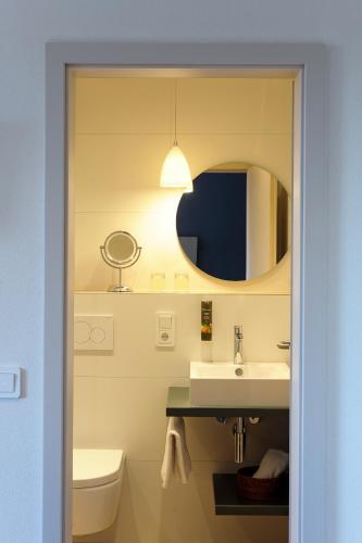 a bathroom with a sink and a mirror at Hotel Wilhelmshöhe Auderath in Auderath