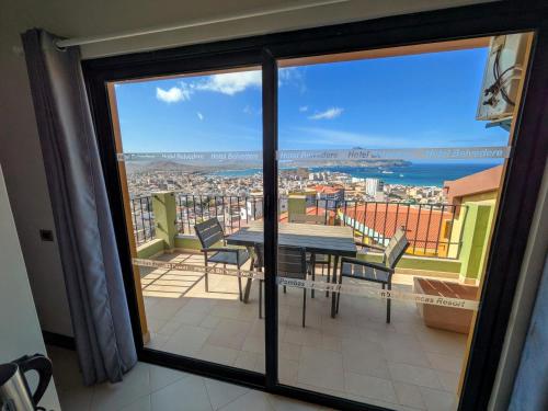 a balcony with a table and chairs and a view of the city at Hotel Belvedere Mindelo, Cabo Verde in Mindelo