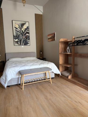 a bedroom with a bed and a bench in it at BYZANTIUM APARTMENTS in Ermoupoli
