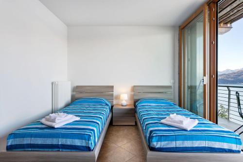 two beds in a room with a balcony at Vista 180 by Halldis in Perledo