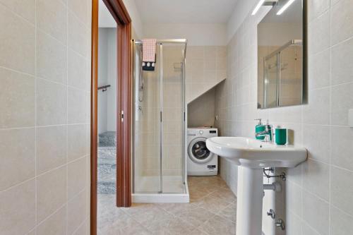 a bathroom with a sink and a washing machine at Vista 180 by Halldis in Perledo