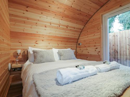 a bedroom with a bed in a wooden cabin at Park View Lodge in Derby