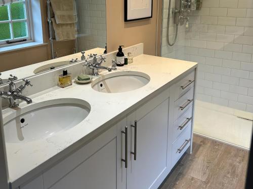 a bathroom with two sinks and a shower at Riverside Cottage in Marlborough
