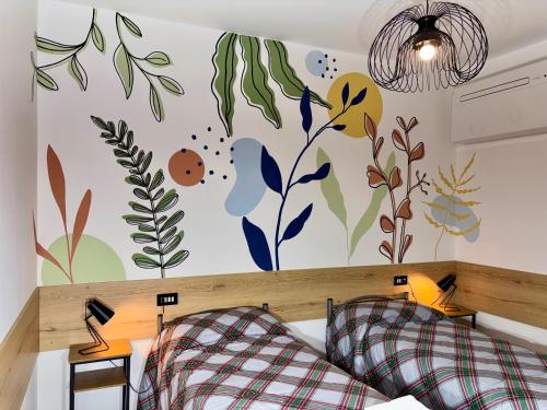 a bedroom with a wall with flowers and plants at Varenna Boulevard in Varenna