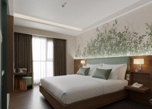 a bedroom with a bed and a painting on the wall at KiN Hotel Central Park in Ho Chi Minh City