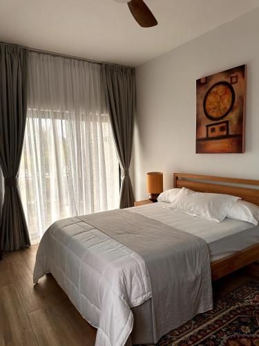 a bedroom with a bed and a large window at Green Heaven Studio in Bois Chéri
