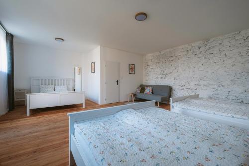 a bedroom with a bed and a stone wall at Stodola Lesůňky in Lesŭňky