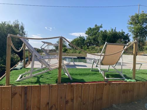 a swing set in a yard next to a fence at Casa Vacanze immersa tra le colline, appartamento, vicinissima al mare e con nuova piscina in Senigallia