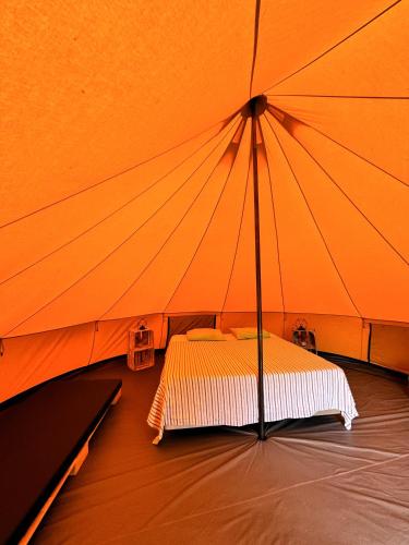 a bed in a large orange tent at Parque da Mina in Monchique