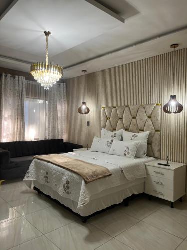 a bedroom with a large bed and a chandelier at M & J Executive Suites in Johannesburg
