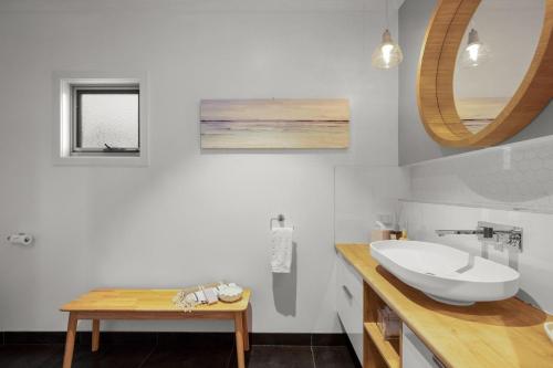 a white bathroom with a sink and a mirror at Guesthouse on Grampian in Cowes