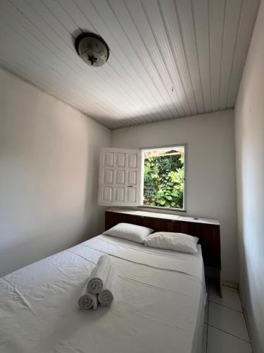 a bedroom with a bed with two towels on it at Casa Canto Verde in Itacaré
