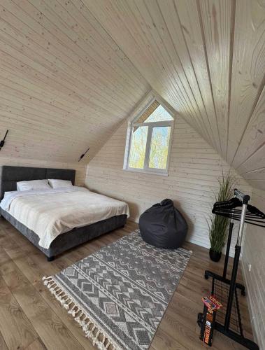 a bedroom with a bed and a window in a attic at Chill House Dnipro in Dnipro