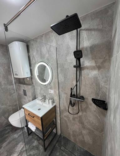 a bathroom with a shower with a sink and a mirror at Chill House Dnipro in Dnipro