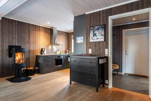 a kitchen with wood paneling and a stove and a counter at Harmony in Geilo, modern and cozy cabin in Geilo