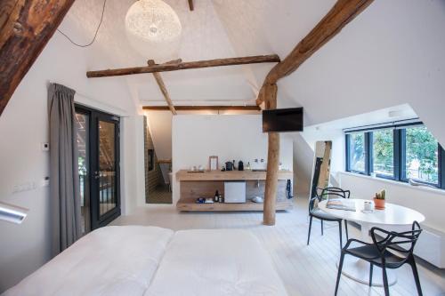 a bedroom with a bed and a table and chairs at Uitgerust voor Zaken in Heerenveen