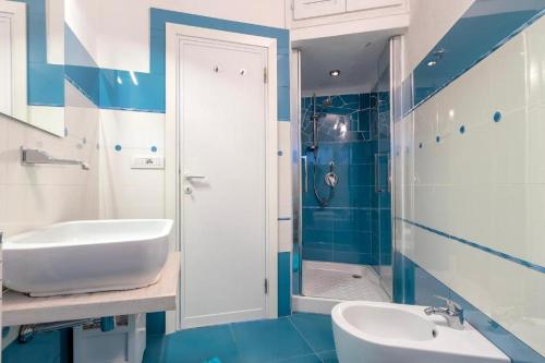 a blue and white bathroom with a sink and a tub at Villa K1- INFINITYHOLIDAYS in Costa Paradiso