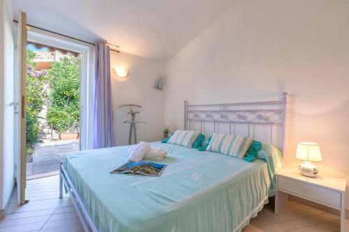 a bedroom with a bed with a blue comforter at Villa K1- INFINITYHOLIDAYS in Costa Paradiso