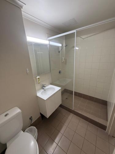 a bathroom with a toilet and a shower and a sink at Budget Motel in Midland Junction